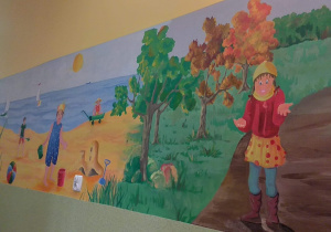 Piękne grafiti w korytarzu przedstawiające bawiące się dzieci w różnych porach roku.